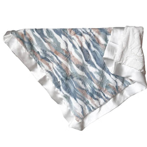Textured fabric with blue and brown pattern draped over a rack against a white wall