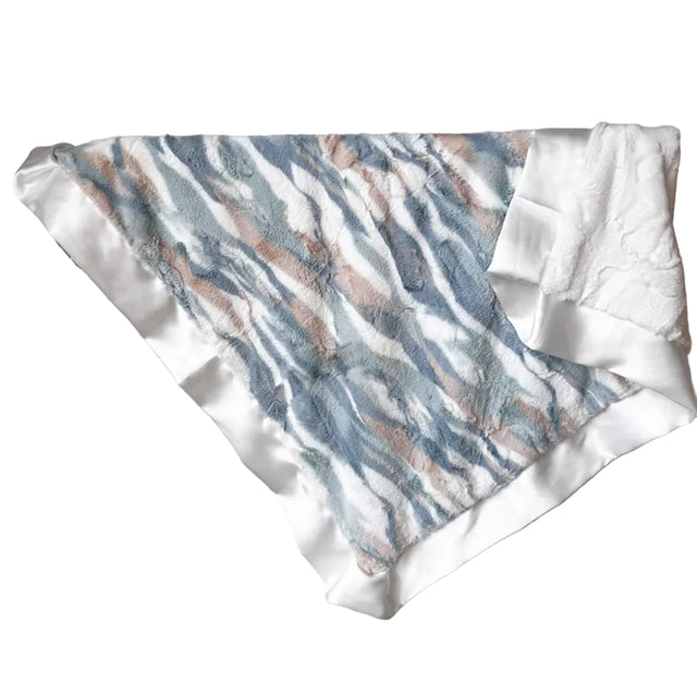 Textured fabric with blue and brown pattern draped over a rack against a white wall