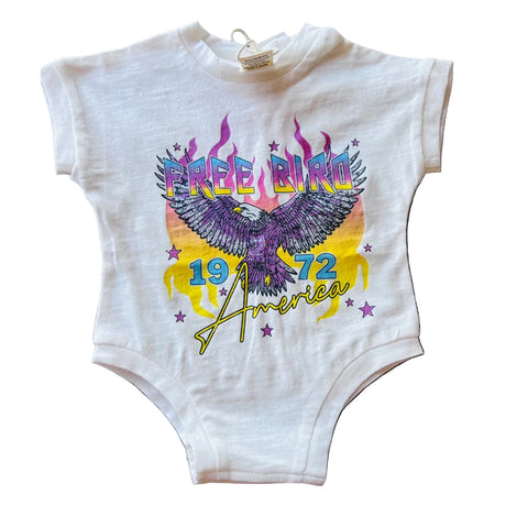 White baby onesie with colorful eagle design and text on a brick background