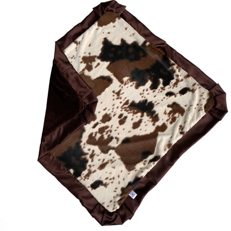 Cow print blanket with brown border on a white background