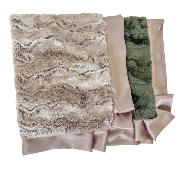 Three folded fabric pieces stacked on a white background: a large taupe faux-fur panel on top, with smooth taupe satin-like fabric and a green faux-fur panel visible behind it.
