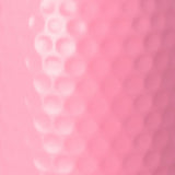 A close-up of a pink textured surface with a raised vertical row of circular dimples on the left and a smoother dotted pattern on the right.