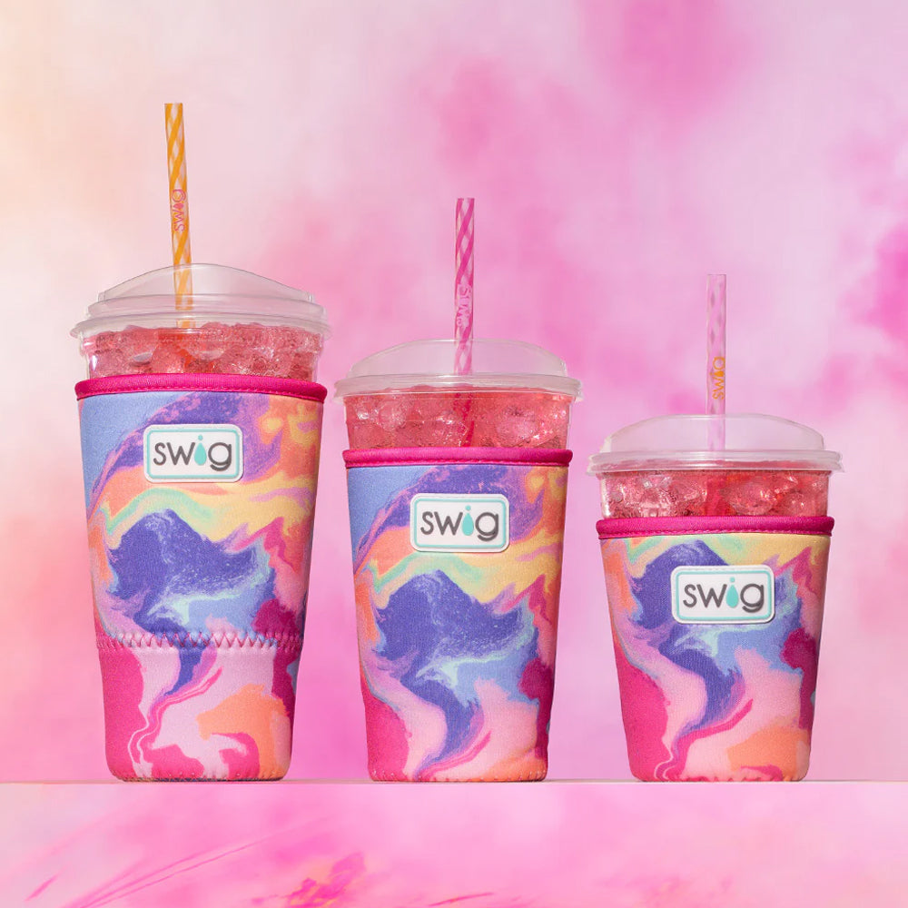 Three colorful swig tumblers with straws on a pink and purple gradient background