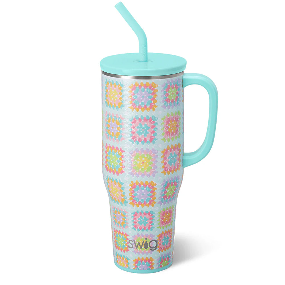 Tumbler with colorful pattern and turquoise handle and straw on a white background