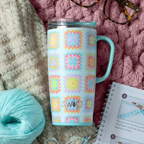 Tumbler with colorful pattern on a textured surface with yarn and glasses