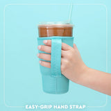 A hand holding a clear plastic iced coffee cup with a straw, wrapped in a light blue neoprene hand strap with a matching carrying handle, against a light blue background with the text 'EASY-GRIP HAND STRAP' at the bottom.