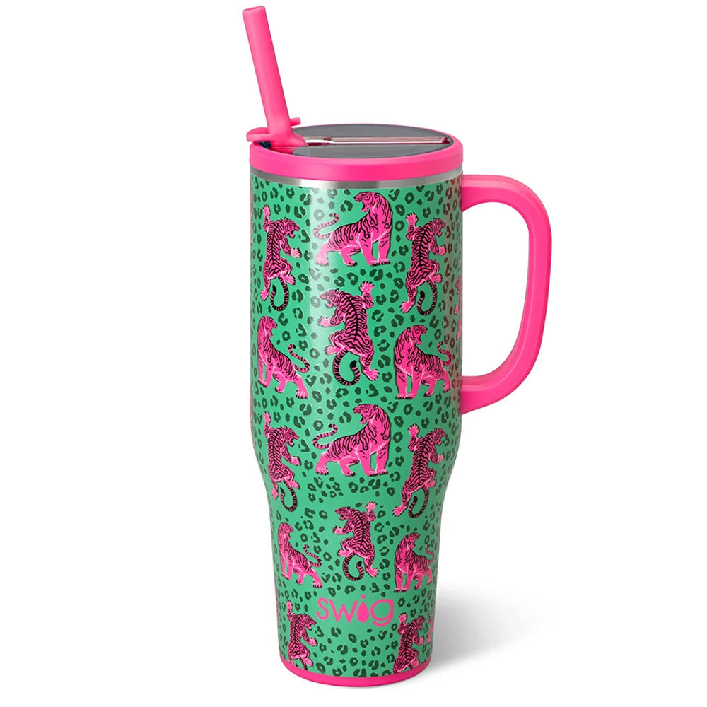 A tall insulated tumbler with a pink handle and straw, featuring a green leopard print background with pink tiger illustrations. The tumbler has a metallic silver lid and is shown on a clean white background.
