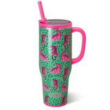 A tall insulated tumbler with a pink handle and straw, featuring a green leopard print background with pink tiger illustrations. The tumbler has a metallic silver lid and is shown on a clean white background.