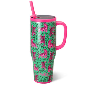 A tall insulated tumbler with a pink handle and straw, featuring a green leopard print background with pink tiger illustrations. The tumbler has a metallic silver lid and is shown on a clean white background.