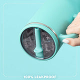 A close-up of a hand holding a mint green insulated tumbler with a clear lid and leakproof silicone seal, set against a matching mint green background with the text '100% LEAKPROOF' at the bottom.
