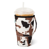 Coffee cup with a cow print sleeve on a white background