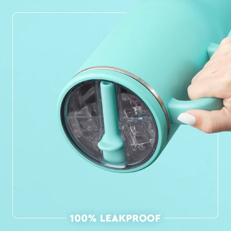 Turquoise ice cream maker with a hand holding it, on a light blue background.