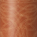 A close-up of a brown leather-like surface with a repeating stitched geometric pattern in a lighter tan color.