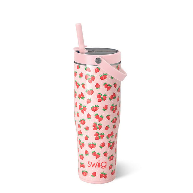 Pink tumbler with strawberry pattern and straw on a white background