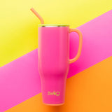 Pink mug with straw on a colorful geometric background