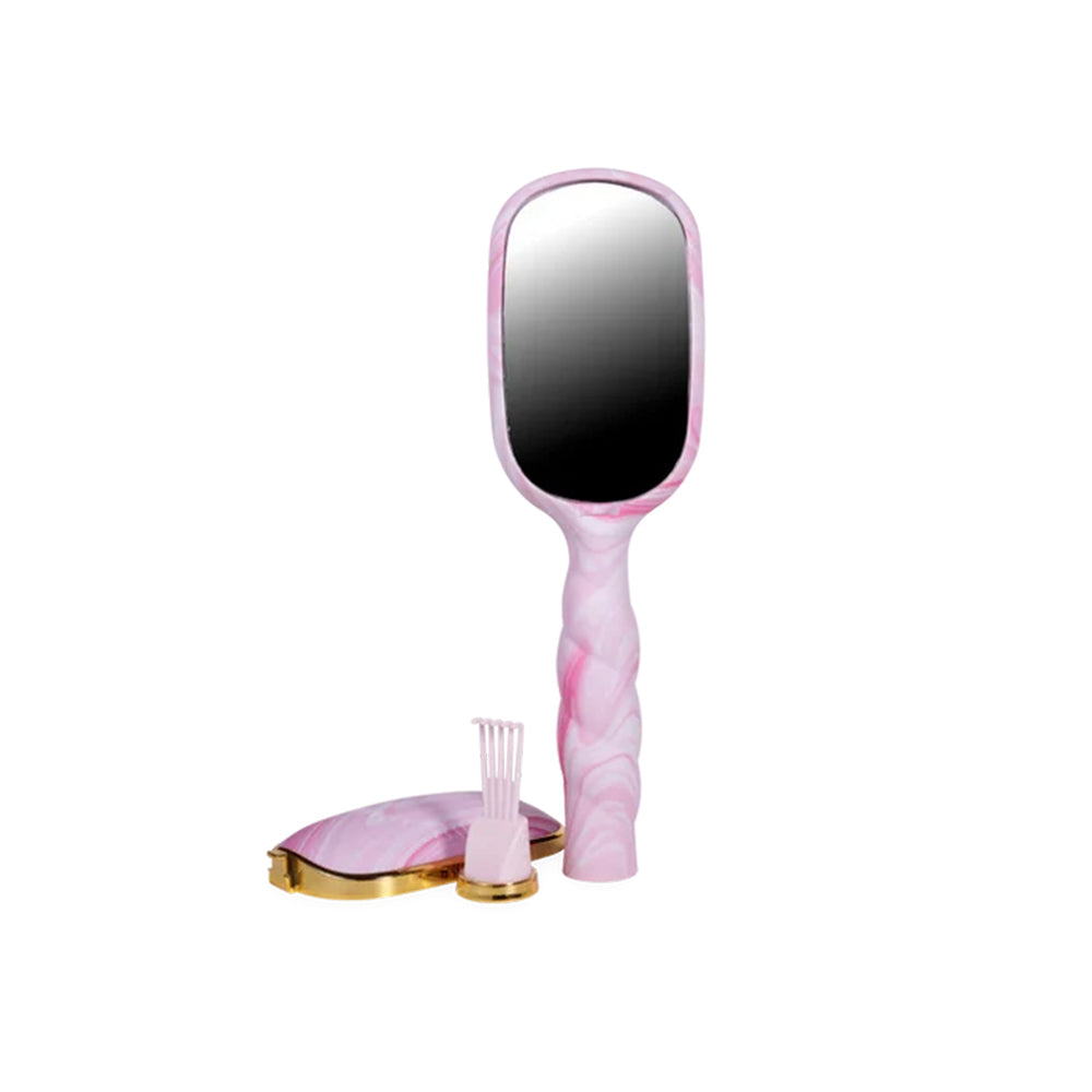 Pink handheld vanity mirror with a twisted handle, shown with a matching pink hairbrush and a gold-trimmed case on a white background.