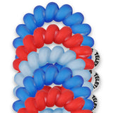 Red, white, and blue hair ties stacked on a white background
