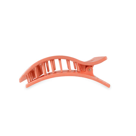 Coral-colored hair clip on a white background