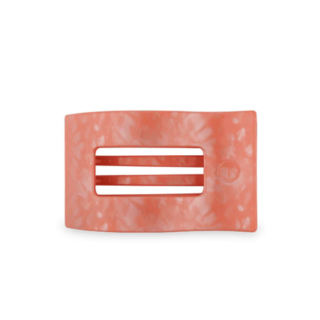 Rectangular pink hair clip with a white label on a white background