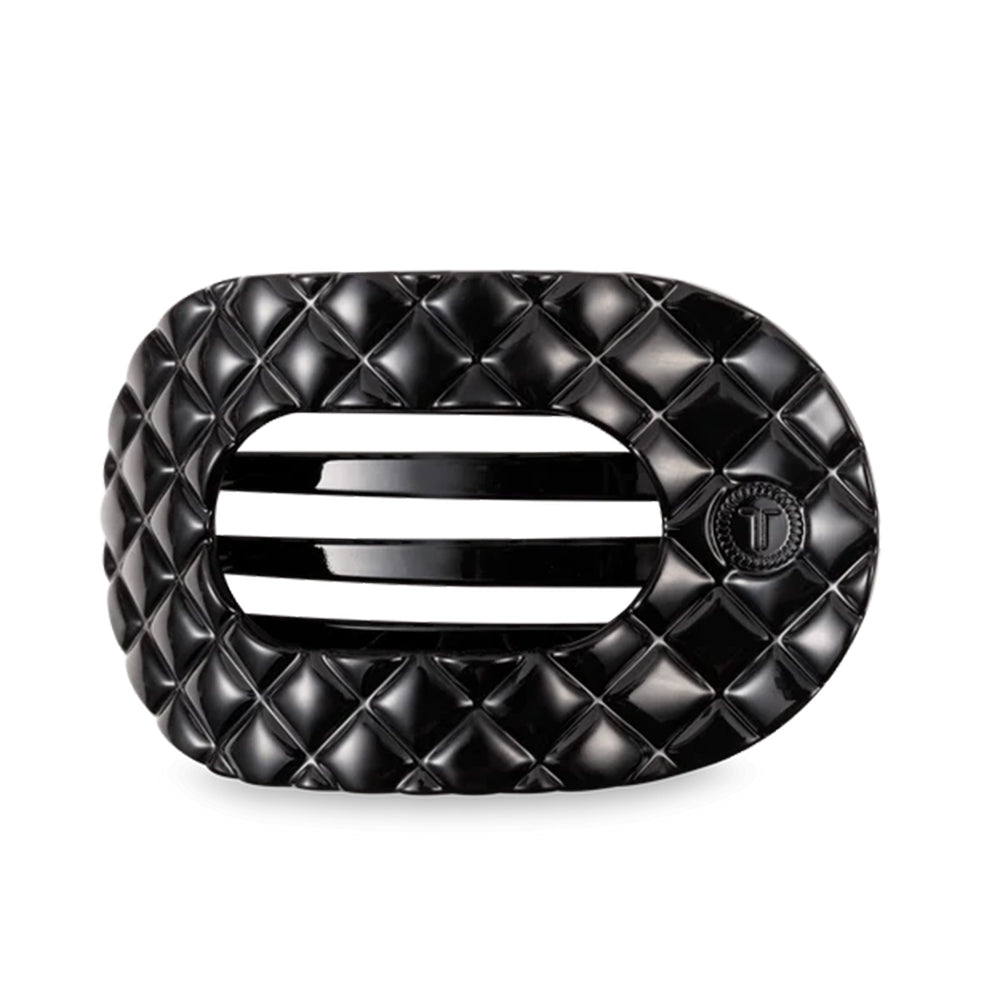 Black quilted hair clip on a light gray background