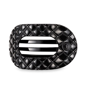 Black quilted hair clip on a light gray background