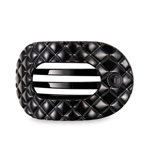 Black quilted hair clip on a light gray background