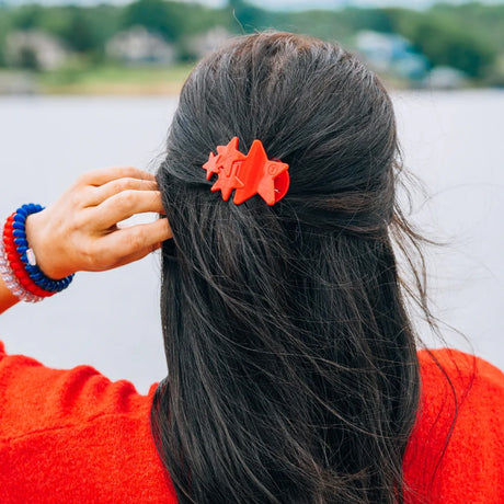 Person with red hair clip by a body of water