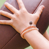 Hand wearing a bracelet on a football