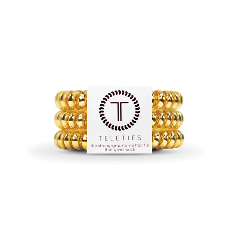 Gold hair ties with Teleties brand label on a white background