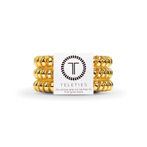 Gold hair ties with Teleties brand label on a white background