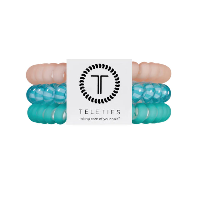 Turquoise hair ties with a brand label on a white background