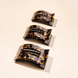 Three tortoiseshell patterned hair clips on a beige background
