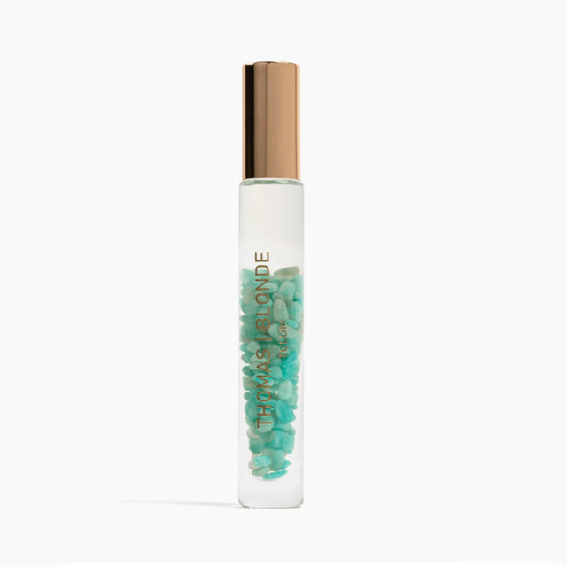 Roll-on bottle with green beads and gold cap on a white background