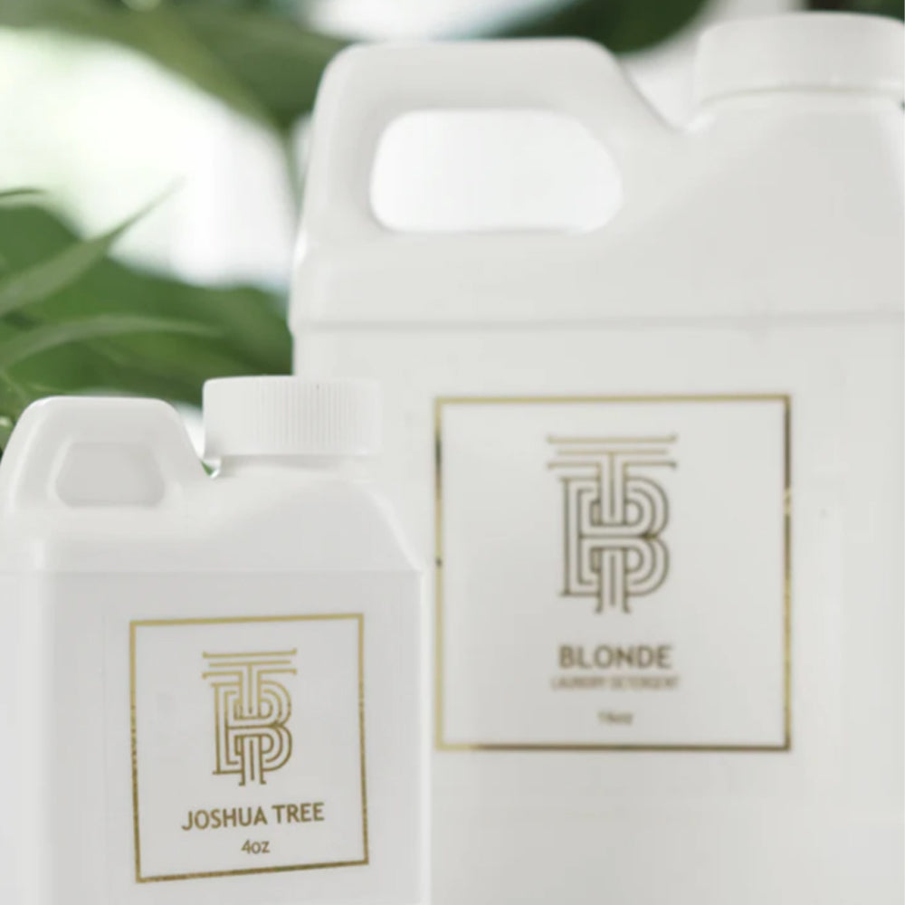 Two white bottles with 'Joshua Tree' branding on a blurred green background