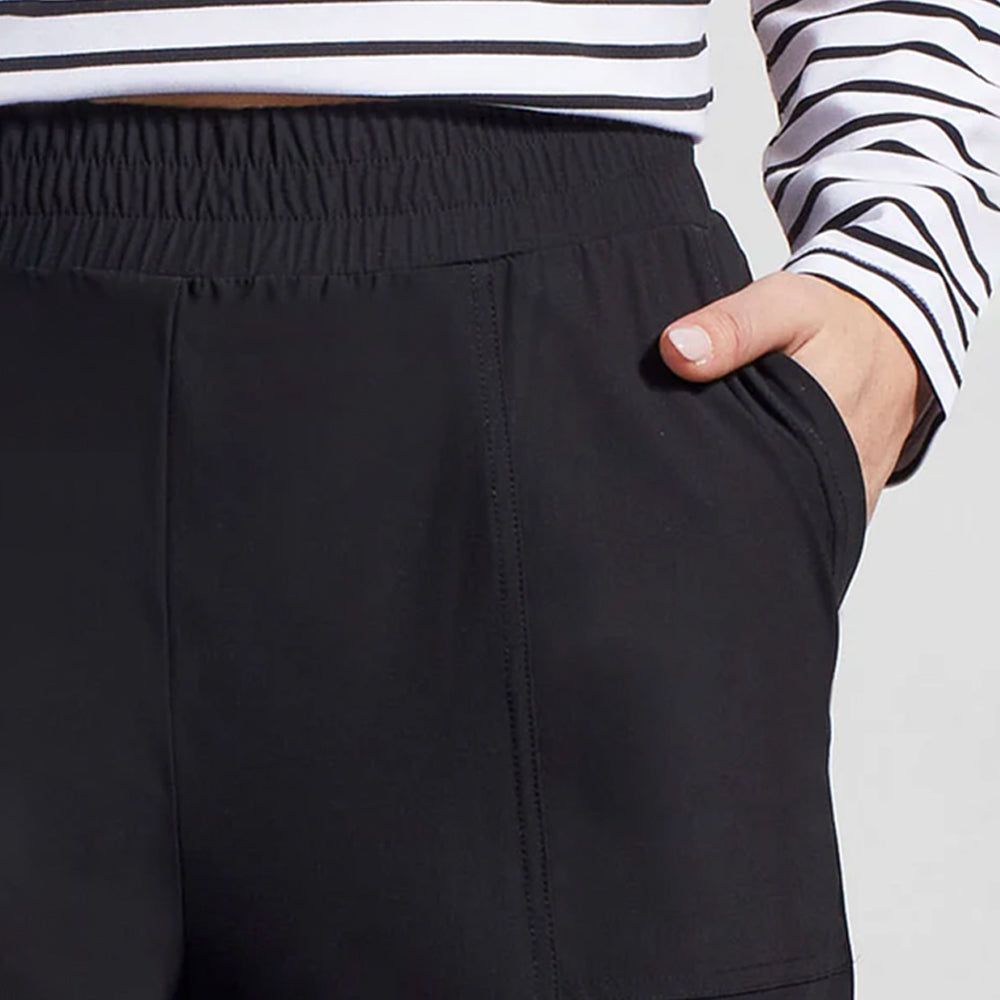 Black pants worn with a striped shirt on a plain background