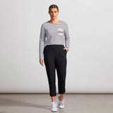 Woman wearing a striped sweater and black pants against a plain background