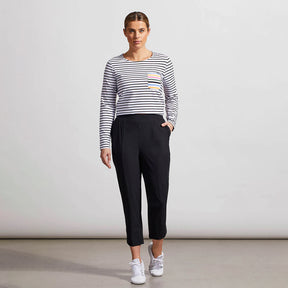 Woman wearing a striped sweater and black pants against a plain background