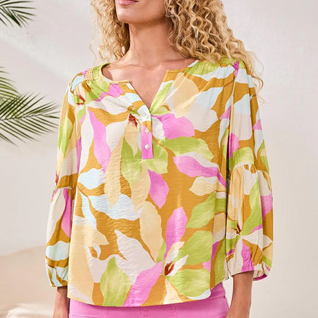 Woman wearing a colorful floral blouse with a blurred background