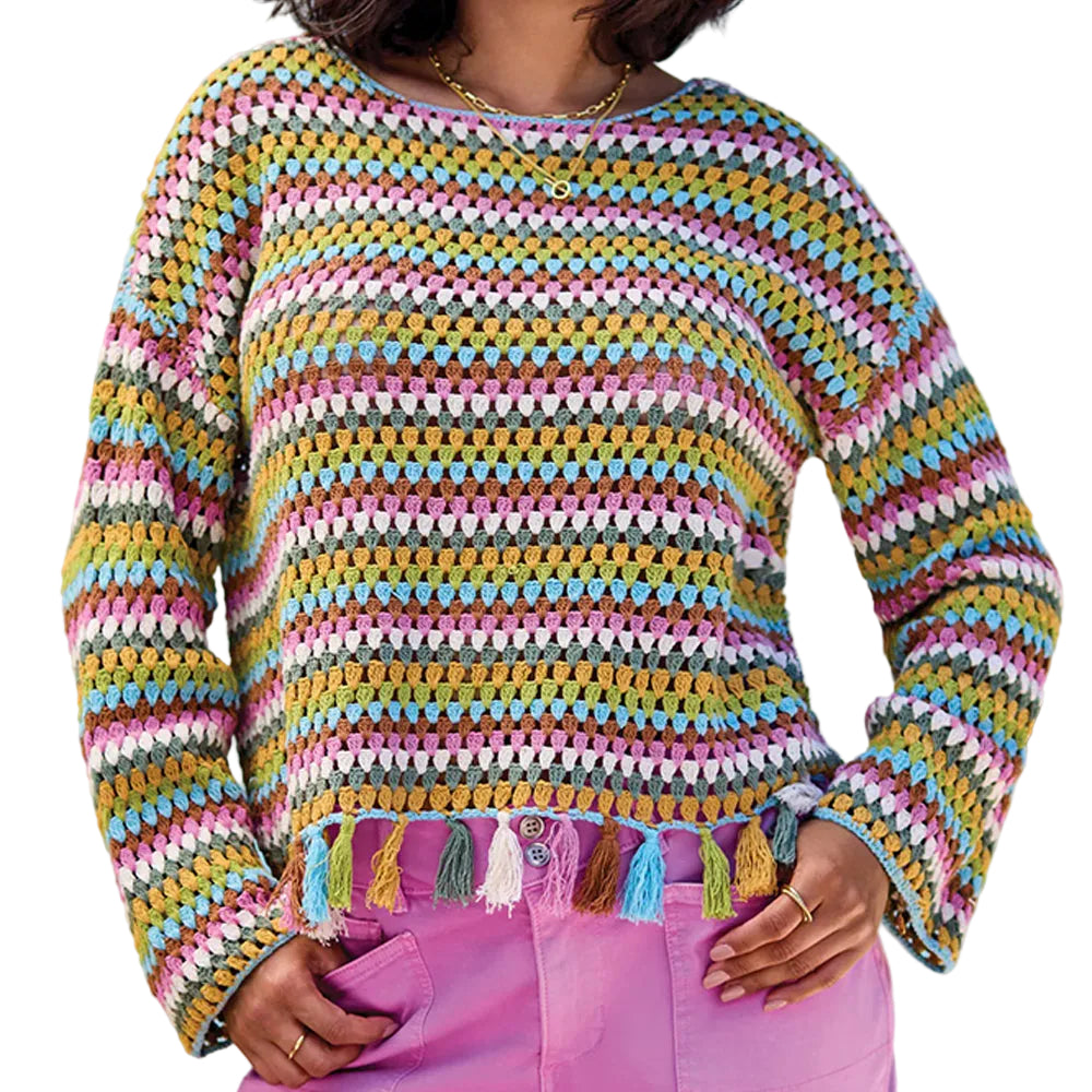 Multicolored crochet sweater with tassels worn by a person against a light blue background