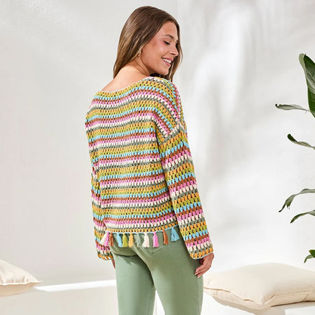 Woman wearing a colorful striped sweater in a bright room.