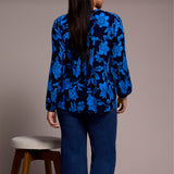 Person wearing a blue floral patterned  against a plain background