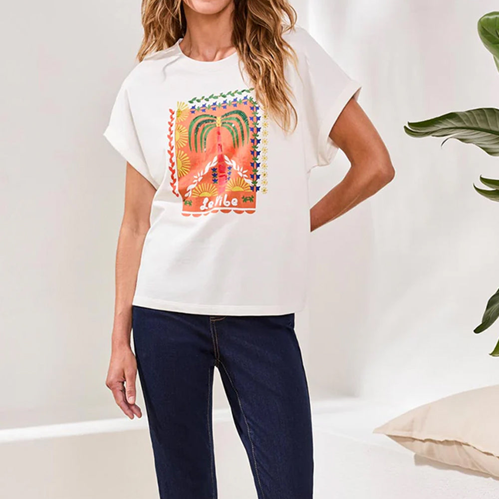 Woman wearing a white t-shirt with a colorful graphic design, standing against a plain background.