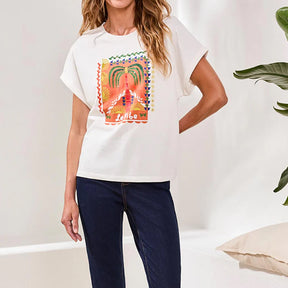 Woman wearing a white t-shirt with a colorful graphic design, standing against a plain background.