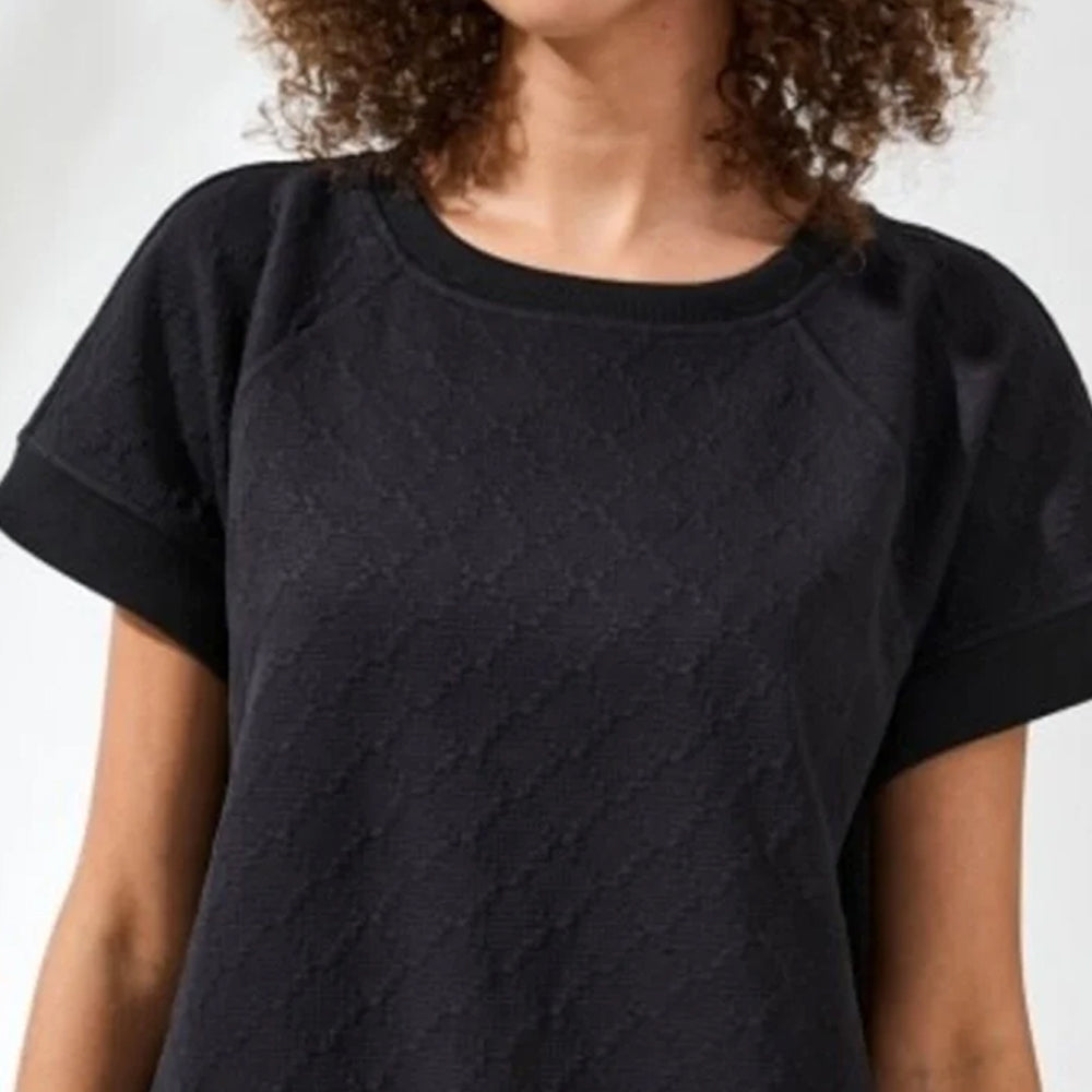 Person wearing a black textured t-shirt against a plain background