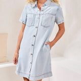 Light blue denim dress worn by a person on a neutral background