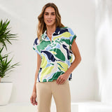 Woman wearing a colorful patterned shirt with a white background