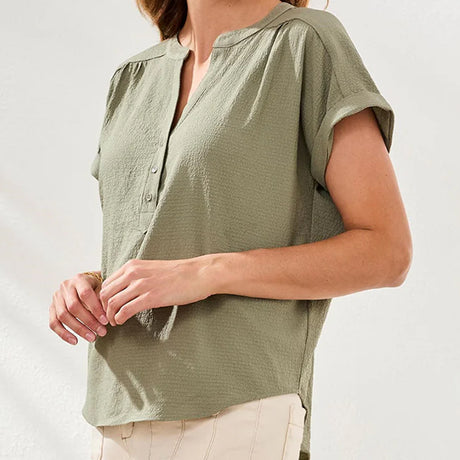 Person wearing a green short-sleeve shirt on a plain background