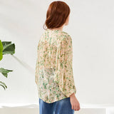 Woman wearing a floral blouse with a white background