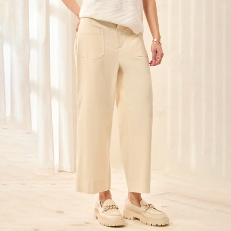 Person wearing beige pants and shoes in a softly lit room