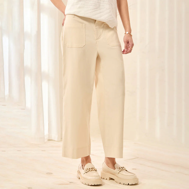 Person wearing beige pants and shoes in a softly lit room